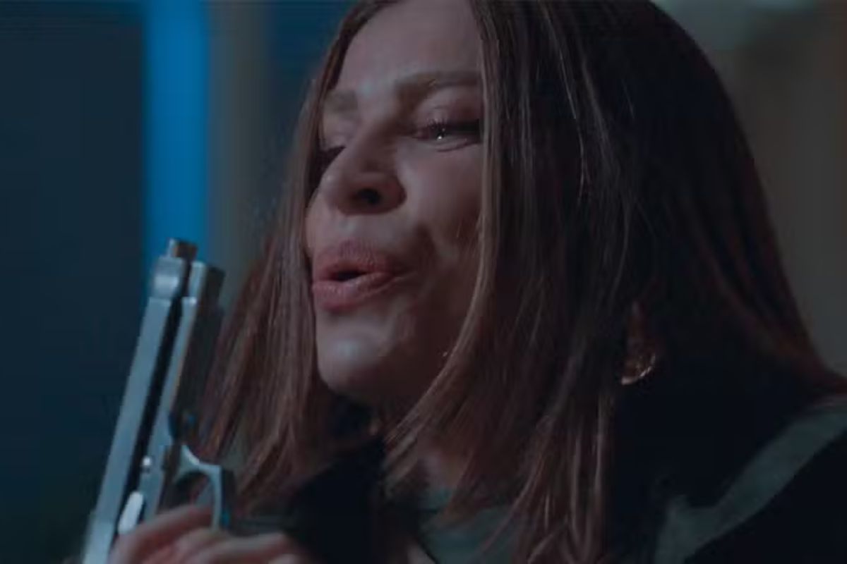 Arminda segurando uma pistola