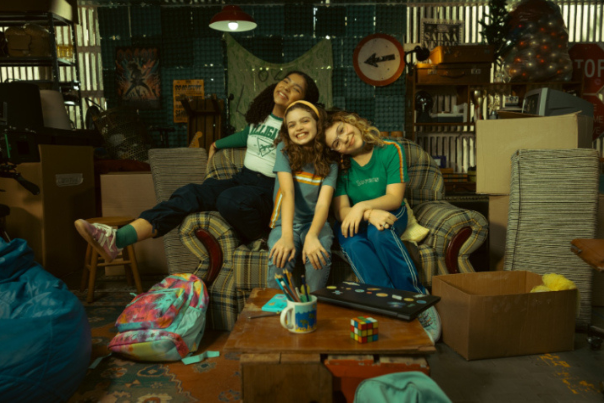 Três meninas em uma garagem, prontas para aventuras